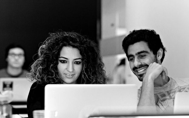 two students taking a ga workshop and smiling at laptop screen